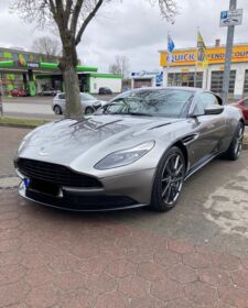 Ein grauer Aston Martin DB11 steht auf einem Parkplatz