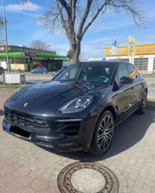 Ein schwarzer Porsche Macan steht auf einem Parkplatz