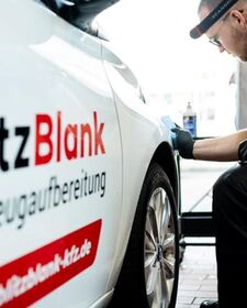 Mitarbeiter wischt einen weißen BlitzBlank Firmenwagen ab