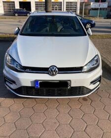 Ein weißer VW Golf VII steht auf einem Parkplatz