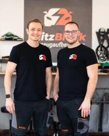 Zwei Inhaber stehen in der Werkstatt vor einem BlitzBlank Logo