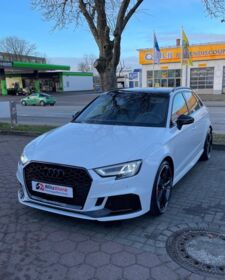 Ein weißer Audi RS 3 steht auf einem Parkplatz