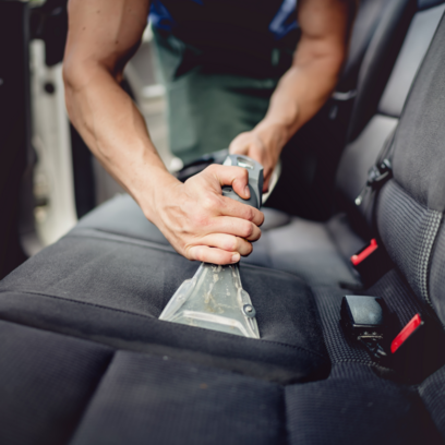 blitzblank-fahrzeugaufbereitung-wagen-innenraum-saugen Eine Person saugt Dreck aus den Innenraum eines Autos