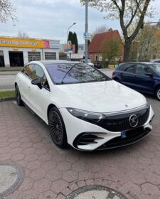 Ein weißer Mercedes Benz EQS steht auf einem Parkplatz