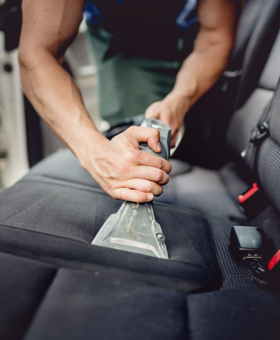 blitzblank-fahrzeugaufbereitung-wagen-innenraum-saugen Eine Person saugt Dreck aus den Innenraum eines Autos